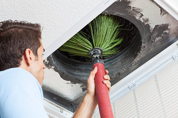Man cleaning air ducts in home.